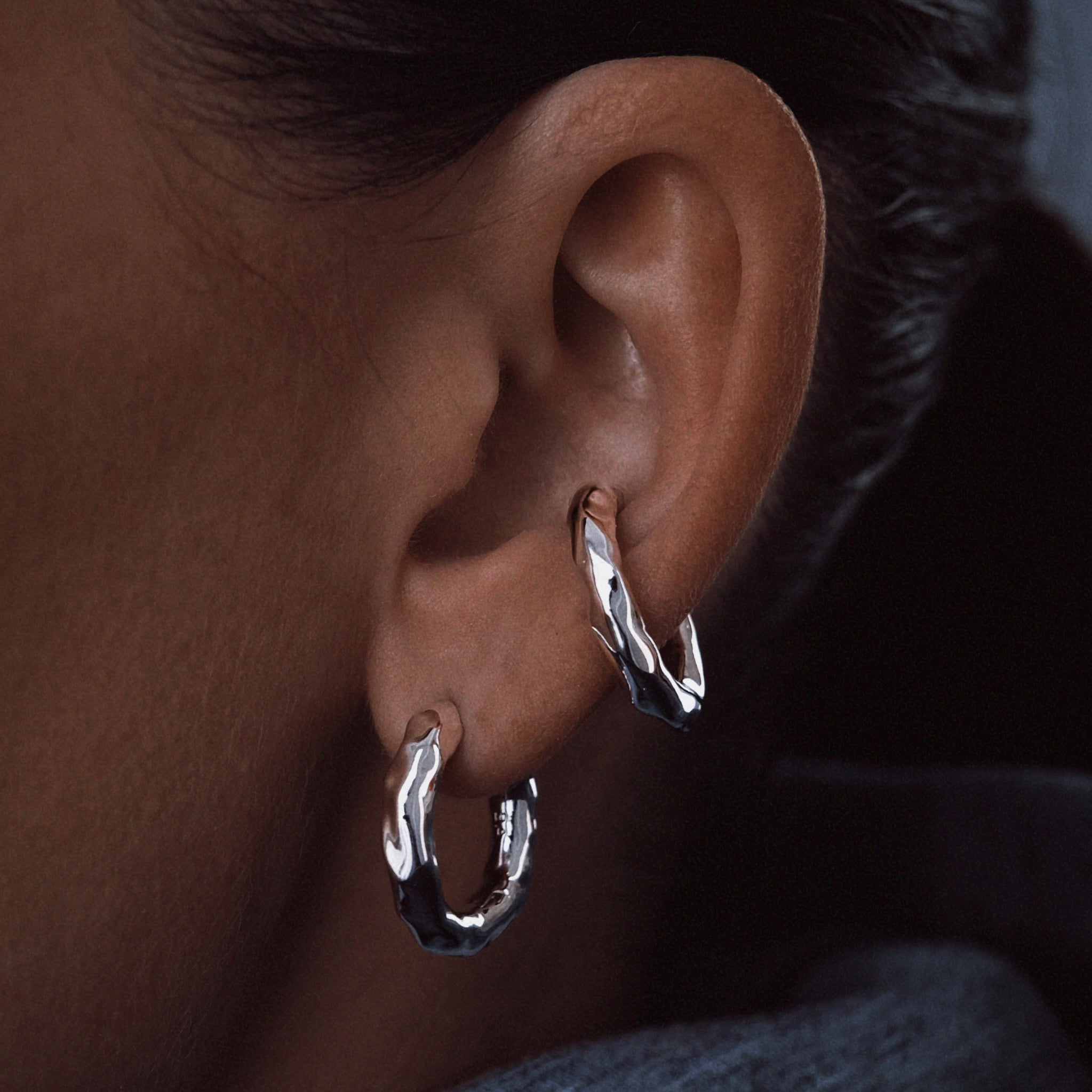 Molten ear cuff in silver color rhodium plated with organic design presented on an ear – Billion Avenue jewelry