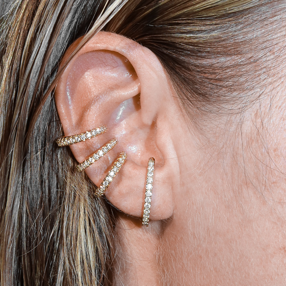 Triple zirconia ear cuff in 14k gold plated presented on an ear – Billion Avenue jewelry